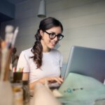 Frau am Schreibtisch arbeitet am Laptop